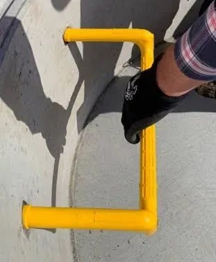 Yellow coated manhole step installation detail in concrete